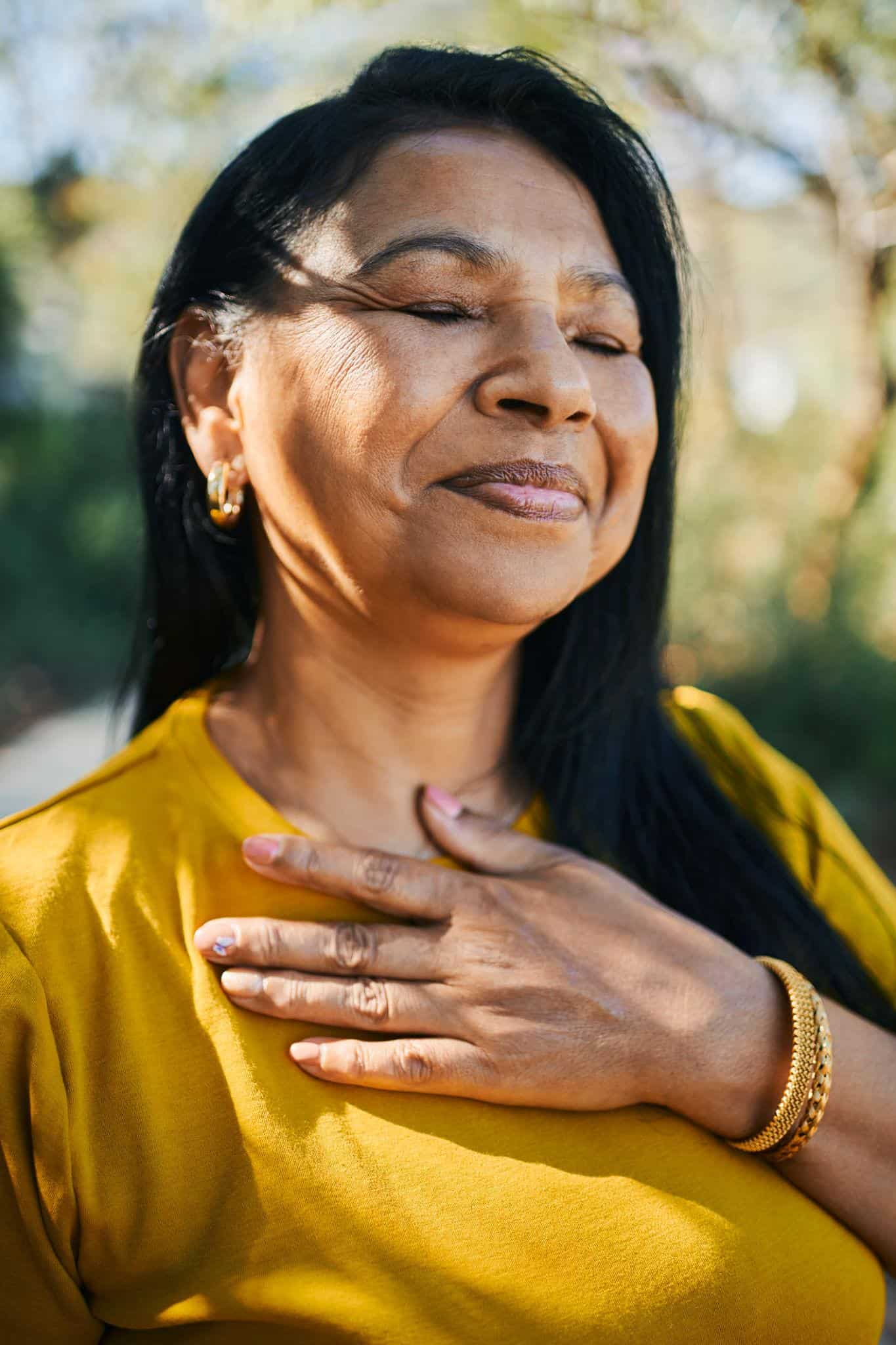 A woman smiling peaceful closed eyes