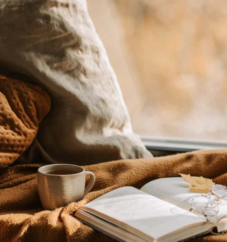 A cozy setting near a window, with an open journal
